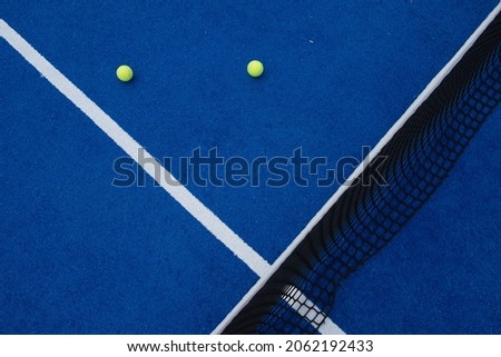 Two balls next to the service line and the net of a paddle tennis court Royalty-Free Stock Photo #2062192433