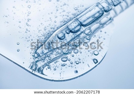 Liquid cool blue gel or serum on blue glass of microscop background Royalty-Free Stock Photo #2062207178