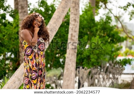Beautiful young multiracial female model posing in a colorful dress at a tropical setting Royalty-Free Stock Photo #2062234577