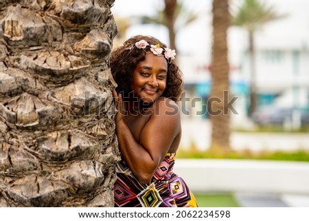 Beautiful young multiracial female model posing in a colorful dress at a tropical setting Royalty-Free Stock Photo #2062234598