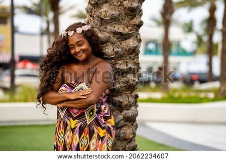 Beautiful young multiracial female model posing in a colorful dress at a tropical setting Royalty-Free Stock Photo #2062234607