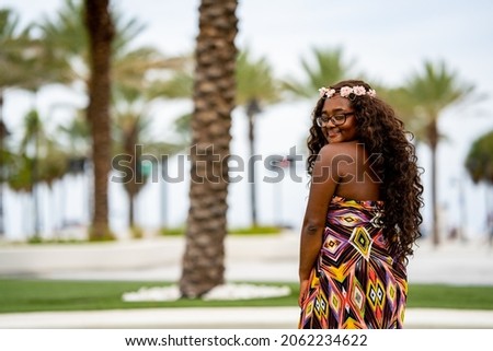 Beautiful young multiracial female model posing in a colorful dress at a tropical setting Royalty-Free Stock Photo #2062234622