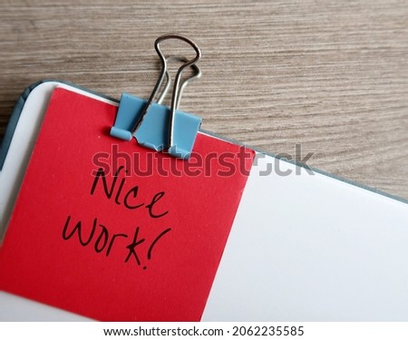 Document with red note compliment in handwriting NICE WORK, concept of giving positive feedback praise in response to a job well done, compliment to staff from boss or client, from teacher to student Royalty-Free Stock Photo #2062235585