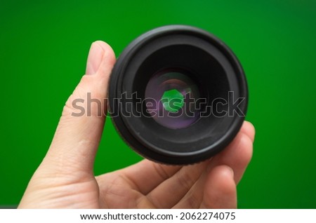 camera lens with open aperture on green background