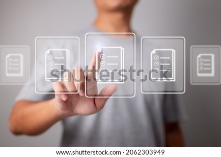 Businessman working on modern computer on virtual screen, paperwork with checkbox lists, compliance rules and law regulatory policy concept. Royalty-Free Stock Photo #2062303949