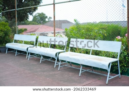 three long chairs on the tennis court