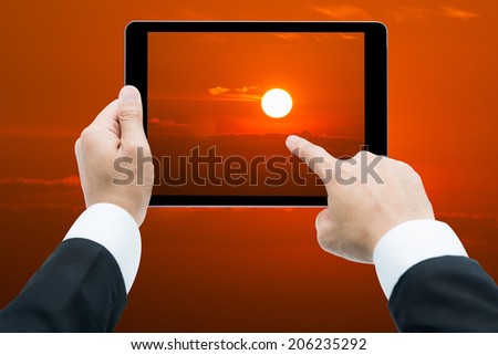 Businessman hands tablet taking pictures Sunrise big sun and cloud