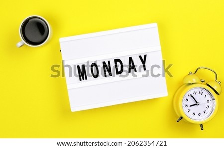 Text monday on lightbox with alarm clock and cup of coffee for holiday - Thank God Its Monday. Start of working week concept. Top view on yellow background.