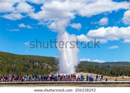 Tourists watching the Old Faithful erupting in Yellowstone National Park, USA Royalty-Free Stock Photo #206238292