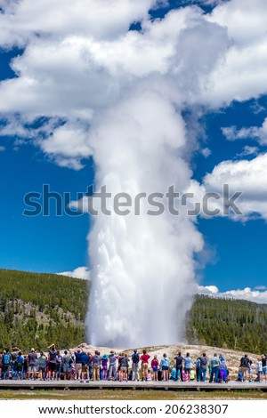 Tourists watching the Old Faithful erupting in Yellowstone National Park, USA Royalty-Free Stock Photo #206238307
