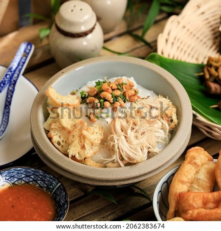 Bubur Ayam or Indonesian Rice  Porridge with Shredded Chicken. Served with Kerukpuk (Cracker), Soy Sauce, Fried Soy Bean, and Sambal Royalty-Free Stock Photo #2062383674