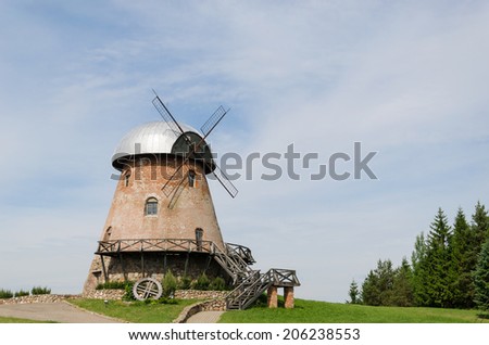 big old retro brick mill with stairs on the summer forest background 