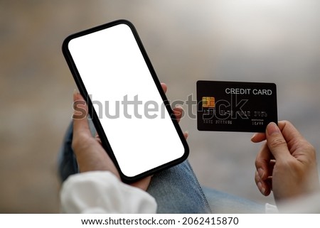  Close up hand of business Woman using a credit card and mobile smartphone for payments and online shopping, Online shopping, digital banking, E-commerce concept.
