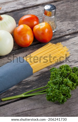 Ingredients for spaghetti on wood table.