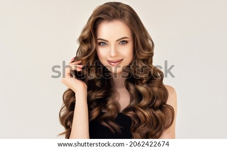 Beautiful laughing brunette model  girl  with long curly  hair . Smiling  woman hairstyle wavy curls . Red  nails manicure .    Fashion , beauty and makeup portrait
 Royalty-Free Stock Photo #2062422674