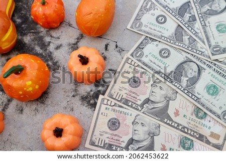Dollar money with pumpkin product decorating and bucket smile face decorating on stone table