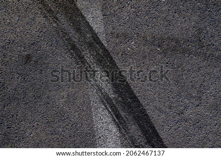 Aerial top view abstract texture and background of car tire drift skid mark on road race track, Black tire mark on street race track, Automobile and automotive concept. Royalty-Free Stock Photo #2062467137