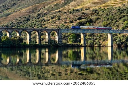historic train on a bridge of the douro line in the middle of the port wine vineyards Royalty-Free Stock Photo #2062486853