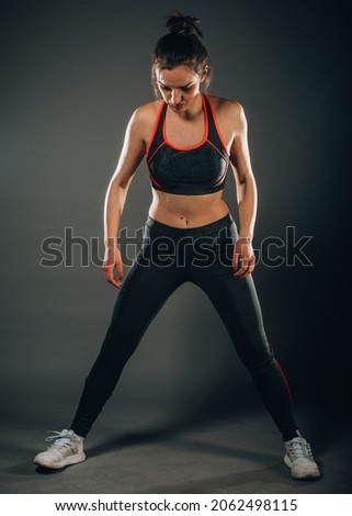 Pretty charming female training and stretching in modern dark studio