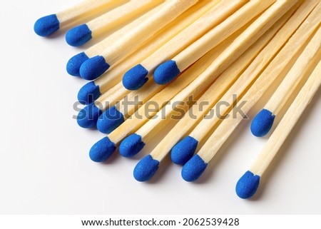 Blue wooden matches on a light gray background. Matchsticks with bright blue heads macro. Scattered wooden matches without box close-up. Design element for smoker accessory concept. Top view. Royalty-Free Stock Photo #2062539428