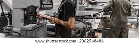 Workers press high-pressure hydraulic hoses on machines. High pressure hydraulic hose manufacturing process. Royalty-Free Stock Photo #2062568486