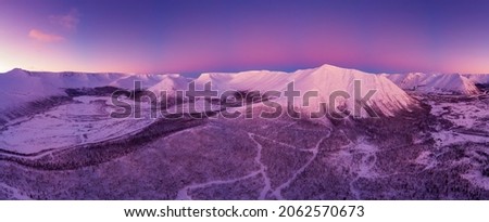 Beautiful sunset in the snowy mountains of the Khibiny above the clouds beyond the Arctic Circle. Kirovsk, Murmansk region.
