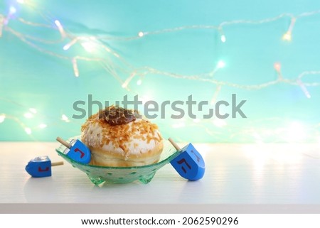 Image of jewish holiday Hanukkah with doughnut and wooden dreidels (spinning top)
