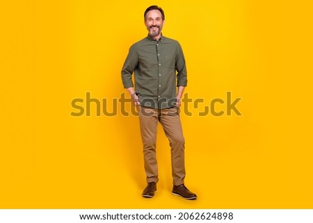 Full length body size view of attractive cheerful man employer holding hands in pockets isolated over vivid yellow color background Royalty-Free Stock Photo #2062624898