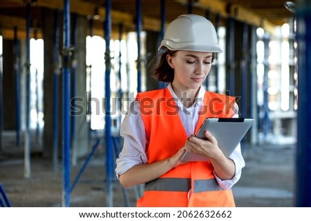 Construction concept of Engineer or Architect working at Construction Site. A woman with a tablet at a construction site. Bureau of Architecture. Royalty-Free Stock Photo #2062632662