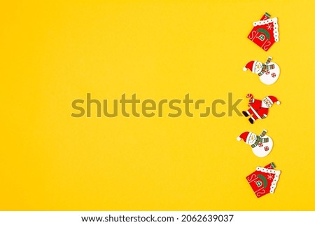 Top view of Christmas and New Year wood decoration on yellow background. Flat lay Xmas red toys with copy space