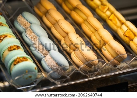 French macaroons. Beautiful macaroons on showcase for selling in cafe. Stylish arrangement sweet. Flat lay, top view. Macro photo.