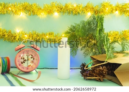 Minimalist concept idea displaying products. cosmetic bottles on christmas and new year background. alarm clock. pine flower
