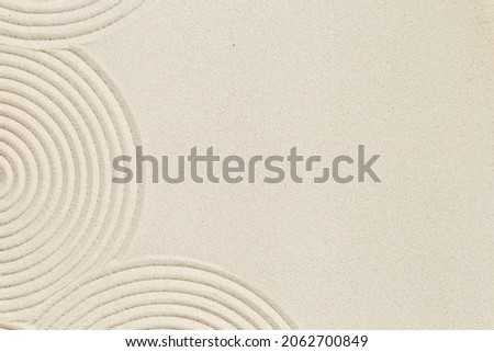 Lines drawing on sand, beautiful sandy texture. Spa background, concept for meditation and relaxation. Concentration and spirituality in Japanese zen garden. View from above. Royalty-Free Stock Photo #2062700849
