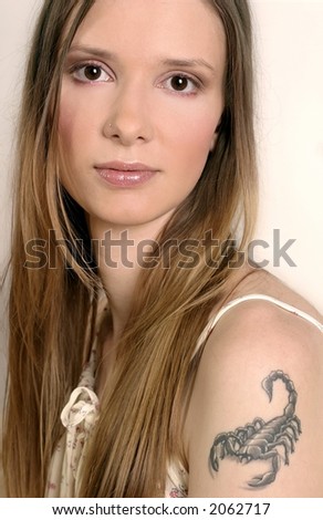 young woman, girl with a scorpio tatoo on her arm