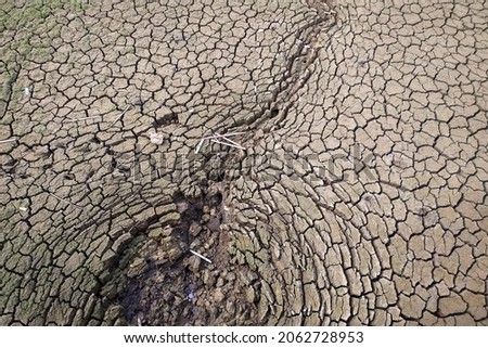 Photo of dry cracked ground due to long drought.