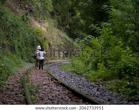 Happy asian family mother and son walk on railroad in summer cloth, railway tracks, lifestyle