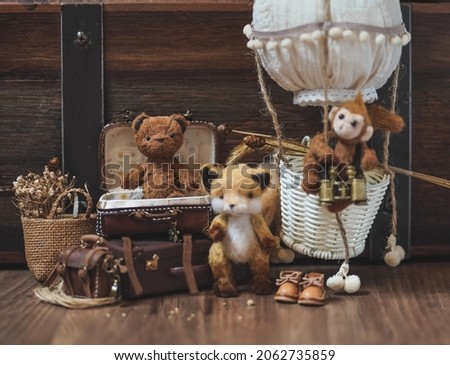 Teddy Bear. Cute miniature dolls made from mo-hair : Teddy Bear, fox and a monkey on the balloon. Vintage film grained filter with retro elements. Traveling concept. Focus on the bear.