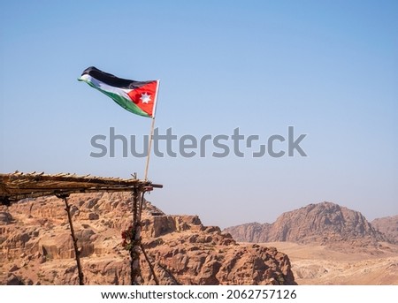 Jordanian flag waving in the wind at a viewpoint  in the ancient city of Petra, Jordan.