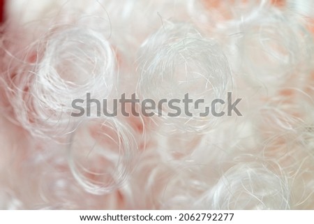 Background from wavy blond artificial hair. Close-up.