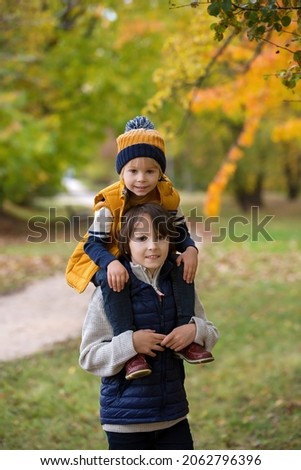 Happy family, funny children, having their autumn pictures taken in the park, children playing