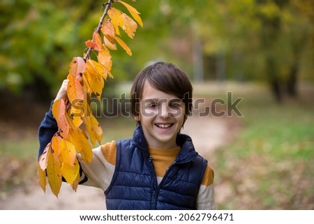 Happy child, posing in autumn park for colorful pictures, children playing