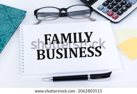 Family Business. Family business written in a white notepad near a pen, a calculator. Business concept.
