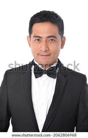 Portrait of young handsome business man in black suit posing in studio