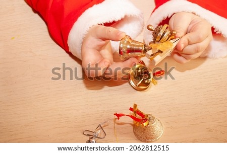 a girl on the background of the table for the New Year 2022 birth dresses up the Christmas tree with toys
