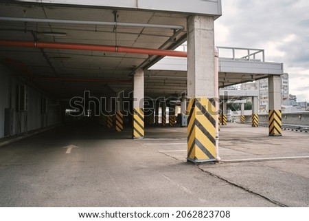 Empty Parking Lot. Underground parking. Empty Parking Garage. Empty shopping mall underground parking lot or garage interior with concrete stripe painted columns. 