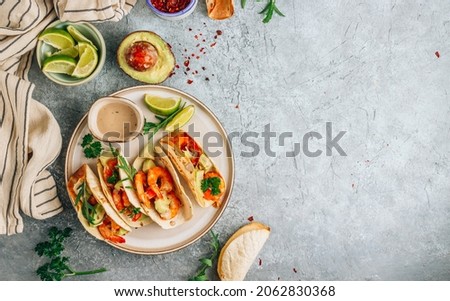 Diet healthy tacos with shrimps and avocado on stone background. Top view
