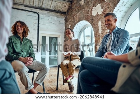 Group therapy session sitting in a circle and laugh. Positive emotions and communication. Royalty-Free Stock Photo #2062848941