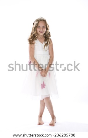 Girl dressed up as little princess standing against white background