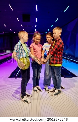 Children poses on the lane in bowling alley