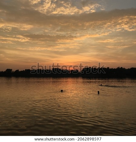 lake in the sunset in summer, clouds, swimming people, forest